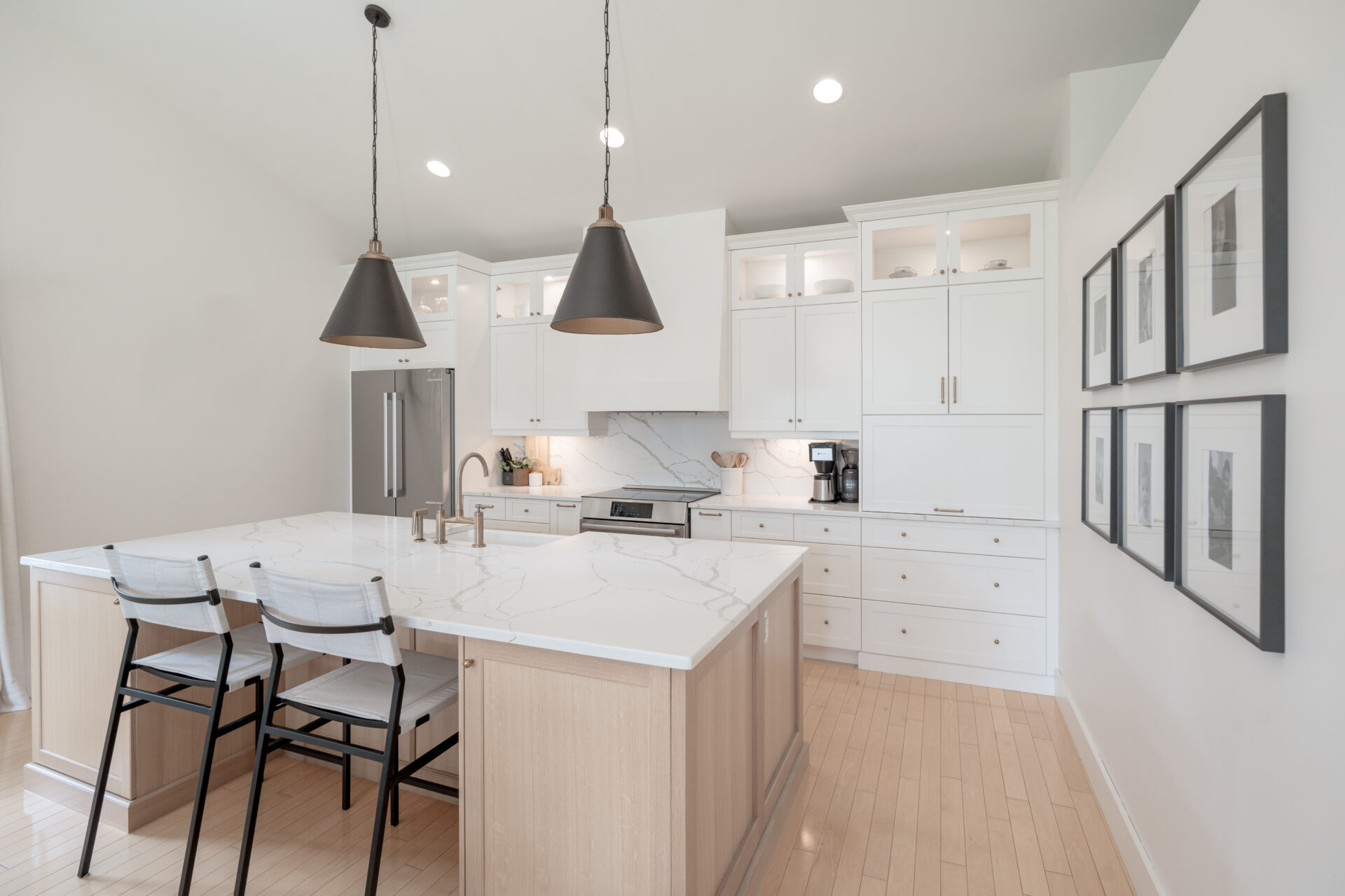 a kitchen with white cabinets and wood floors